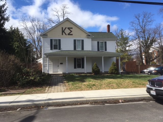 White two-story house with Kappa Sigma letters over the porch, March 2018