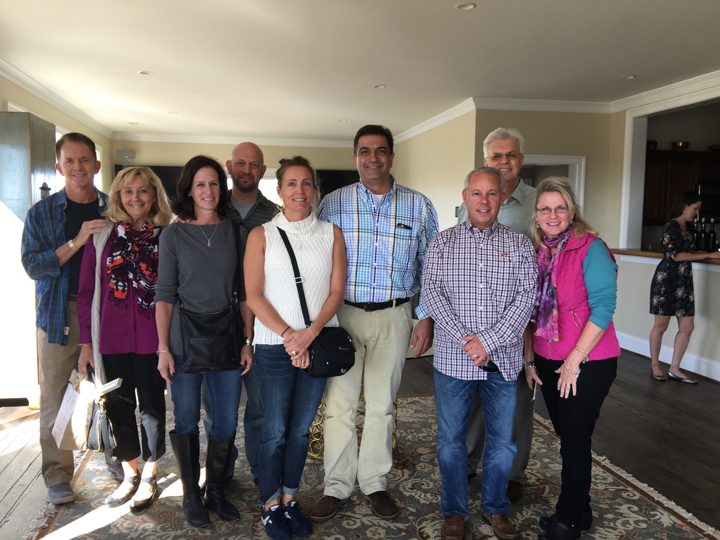 Brothers and wives standing together in a winery tasting room